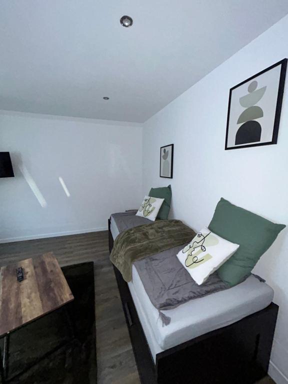 a bedroom with two beds and a wooden table at Charmant studio au bord du lac d’Elancourt village in Élancourt