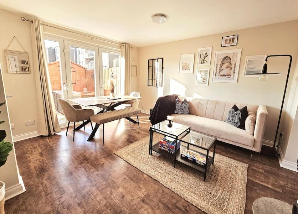 uma sala de estar com um sofá branco e uma mesa em Modern 5 Bedroom Townhouse with Free Parking em Glasgow