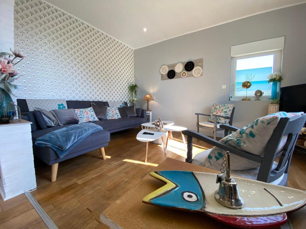 uma sala de estar com um sofá azul e uma prancha de surf no chão em Ker Arcadia em Pleurtuit