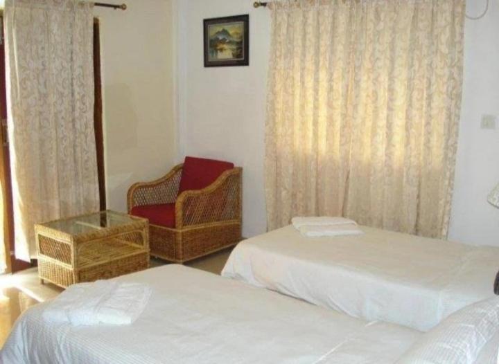 Un pat sau paturi într-o cameră la Hotel Poonam Mahal