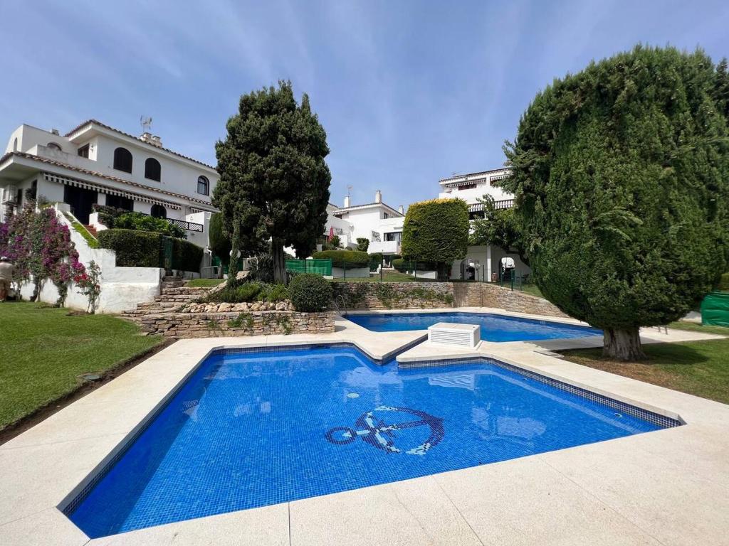 a large blue swimming pool in front of a house at Casa de Playa in Estepona