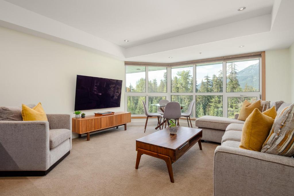 a living room with two couches and a tv at Perfect Upper Village Ski In-Ski Out Location in Whistler