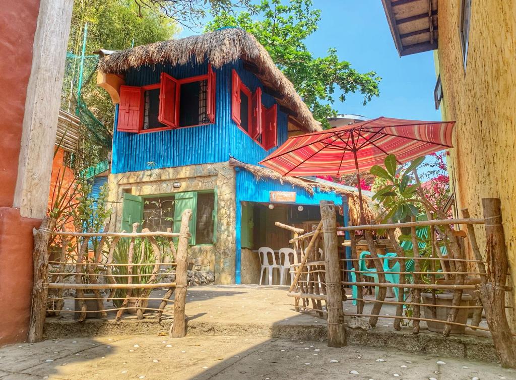 a blue building with a restaurant with an umbrella at Beach House-Casita in Calatagan with pool ( for 6) in Calatagan