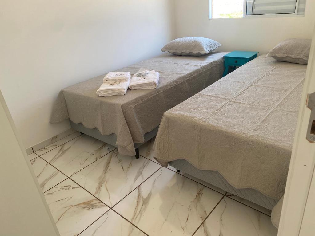 two beds sitting next to each other in a room at Apart. Bela Vista in Pôrto Ferreira