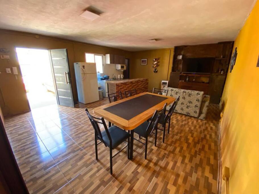een eetkamer met een tafel en stoelen en een keuken bij Casa en pinar del norte san luis in Barranca Colorada