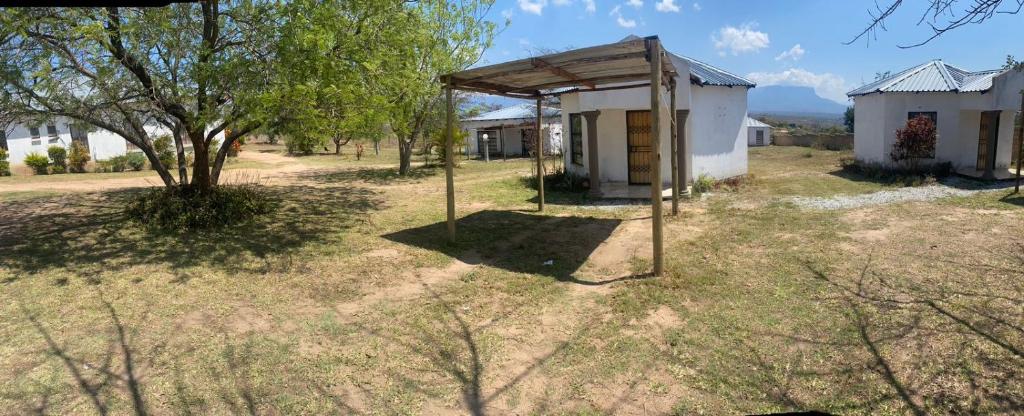 a small building in the middle of a field at Khutsong Lodge in Acornhoek