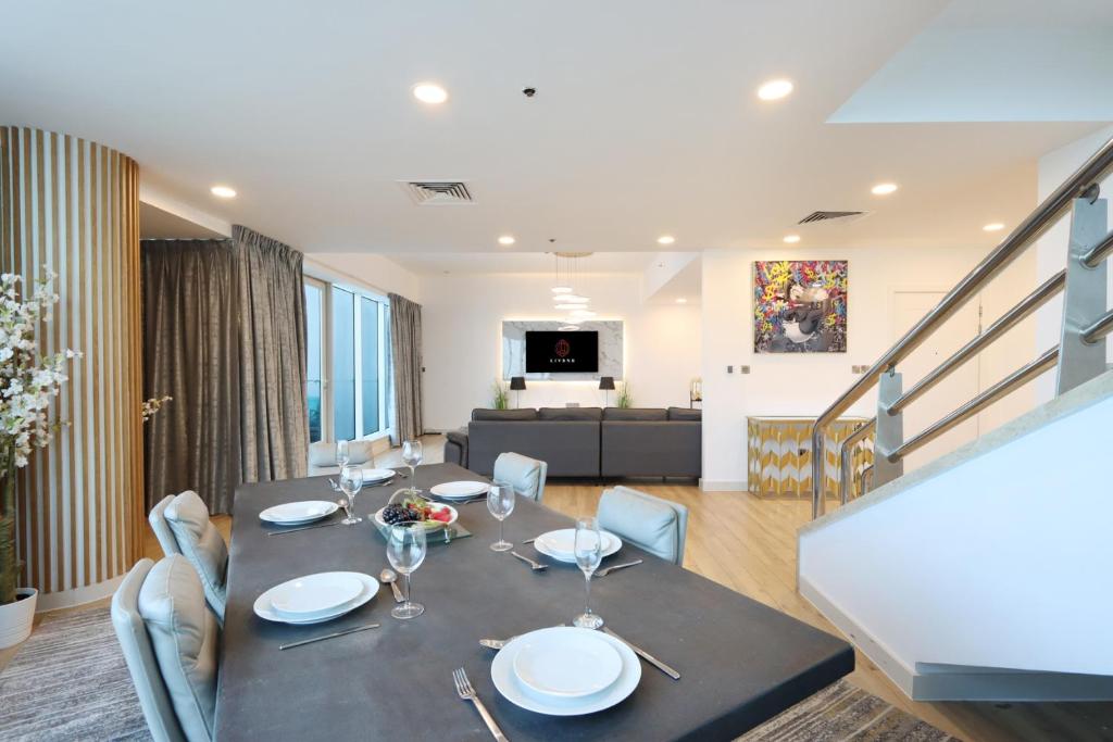 a dining room with a black table and chairs at Duplex Penthouse with Maid's Room - Dubai Marina - Livbnb in Dubai