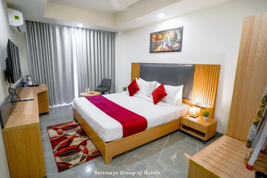 a hotel room with a bed and a television at Saltstayz Le Icon- Cyber Hub and DLF Downtown -8KM from IGI Airport in Gurgaon