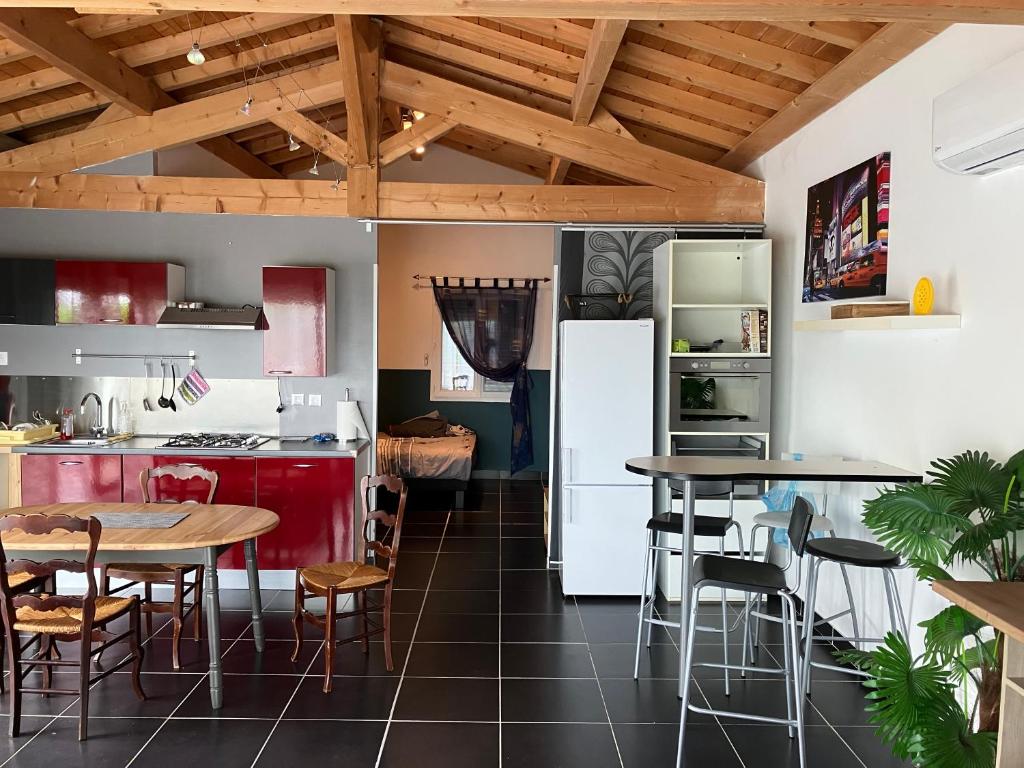 een keuken met 2 tafels en een koelkast bij Mon Hacienda in Caumont
