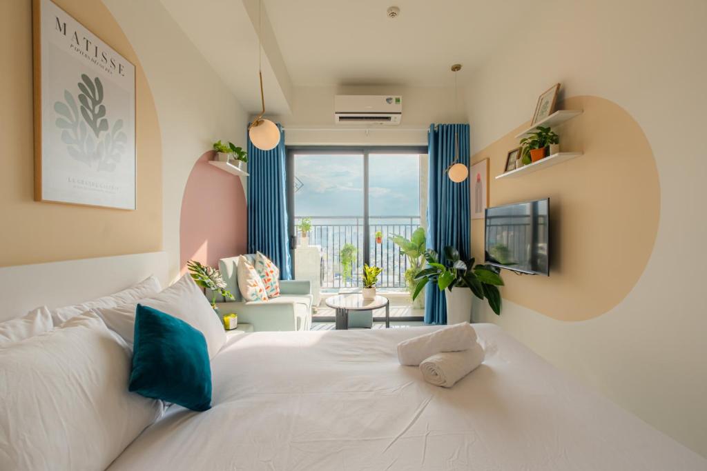 ein Schlafzimmer mit einem weißen Bett und ein Wohnzimmer in der Unterkunft 9TRIP STAY in Soho Residence - Service Apartment in Ho-Chi-Minh-Stadt