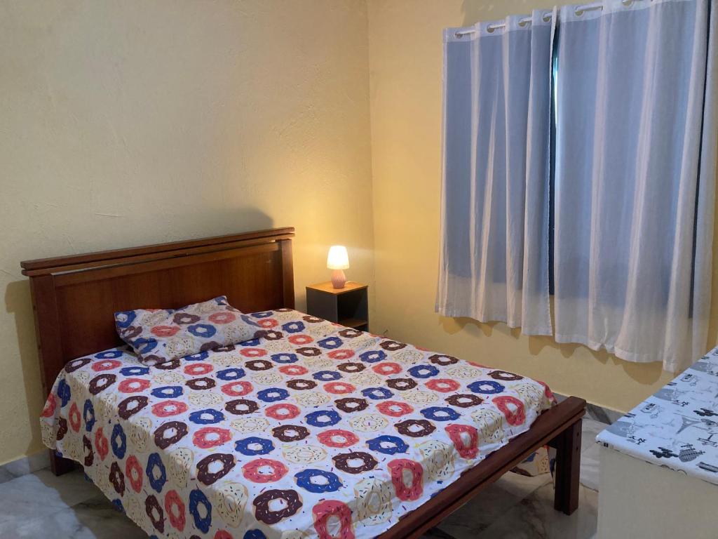 een slaapkamer met een bed en een raam bij Dunas Beach in Cabo Frio
