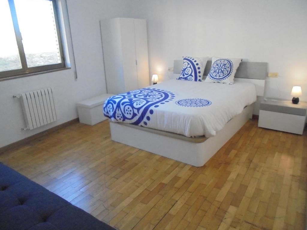 um quarto com uma cama com almofadas azuis e brancas em Jaen Apartment em Ponferrada