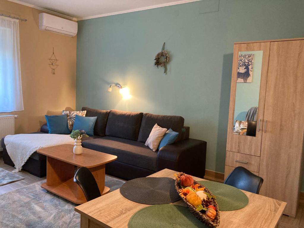a living room with a couch and a table at Levendula Apartmanház in Gyomaendrőd