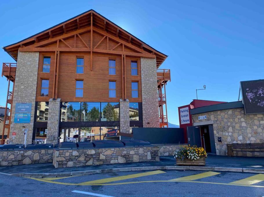 um grande edifício com um telhado de madeira em T2 avec vue à 30m des télécabines em Font Romeu Odeillo Via