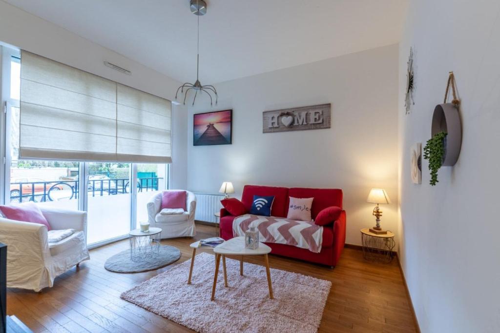 un salon avec un canapé rouge et une table dans l'établissement Warm studio 100m from Place Morny and Port, à Deauville