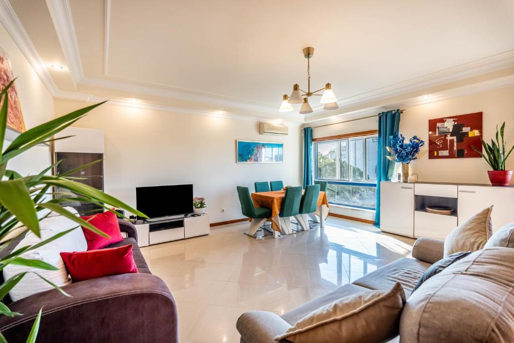 uma sala de estar com um sofá e uma televisão em Relaxing and Central T3 Flat em Portimão
