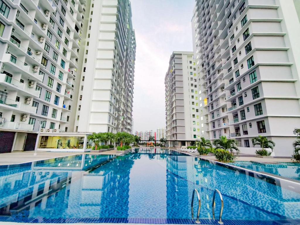 a swimming pool in the middle of two tall buildings at Paradigm Mall 1BR-Poolview-Netflix-WiFi by JB RelaX Homestay in Johor Bahru