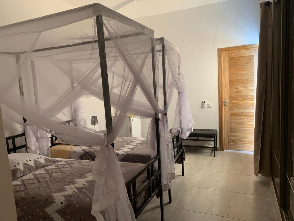 a bedroom with two bunk beds with a canopy at Chambre meublée indépendante Les Hirondelles in Ngaparou