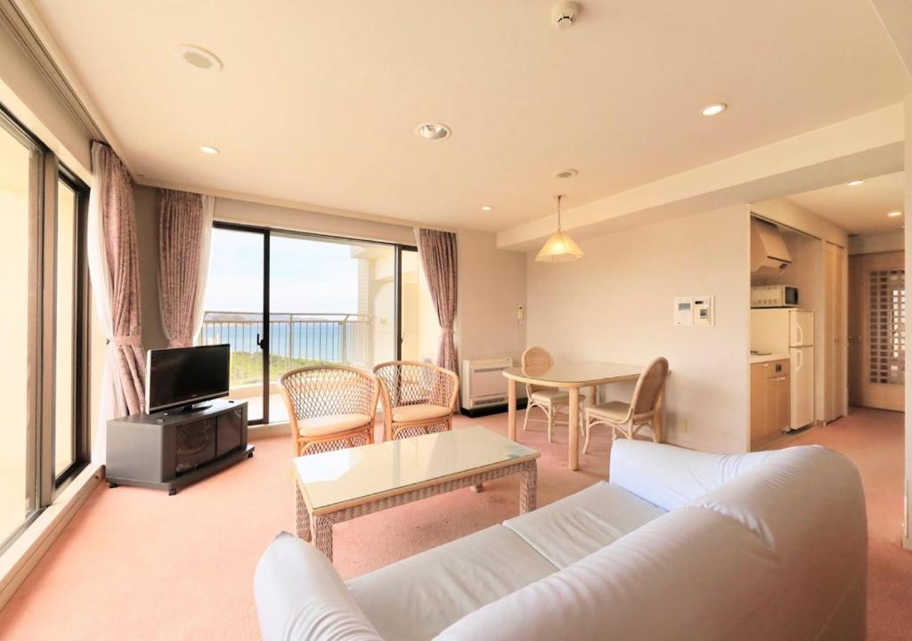 a living room with a white couch and a table at Kamogawa Grand Tower - Vacation STAY 53387v in Kamogawa