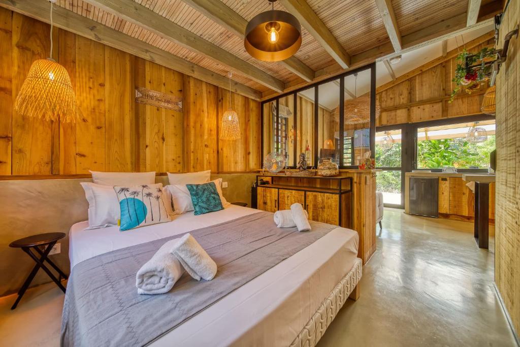 1 dormitorio con 1 cama grande en una habitación con paredes de madera en Oasis des Colibris, en Étang-Salé