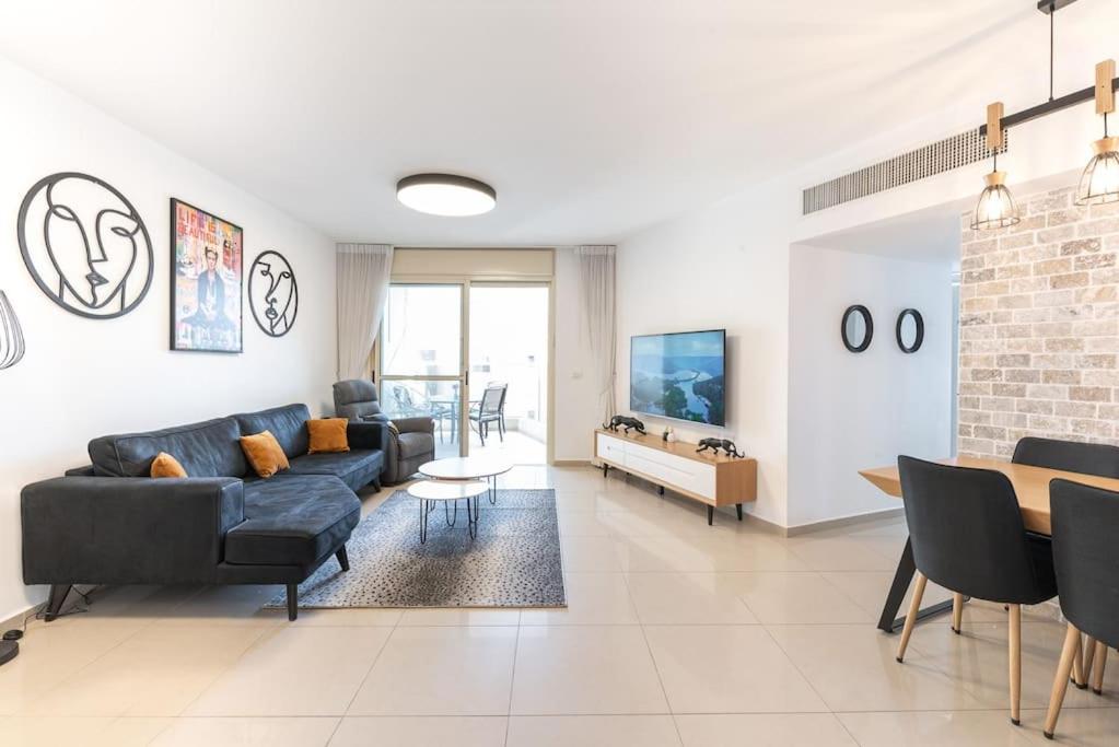 里雄莱锡安Neat 4BR Apt. With Parking/High Floor/Elevator/AC的带沙发和桌子的客厅