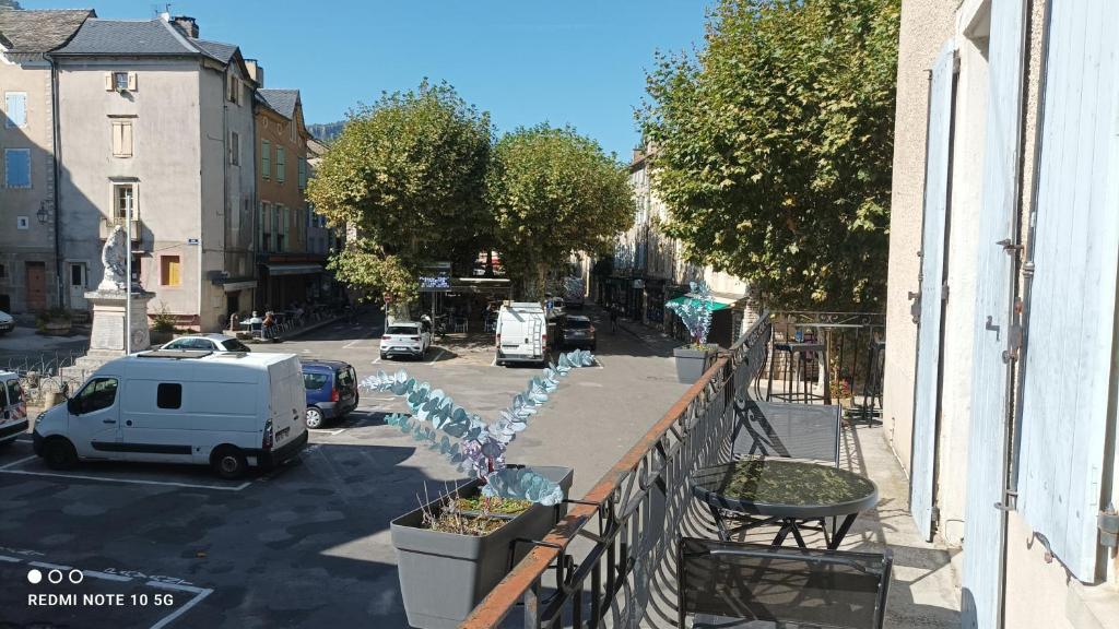 a balcony with a white van parked on a street at FLORAC AUTHENTIQUE in Florac