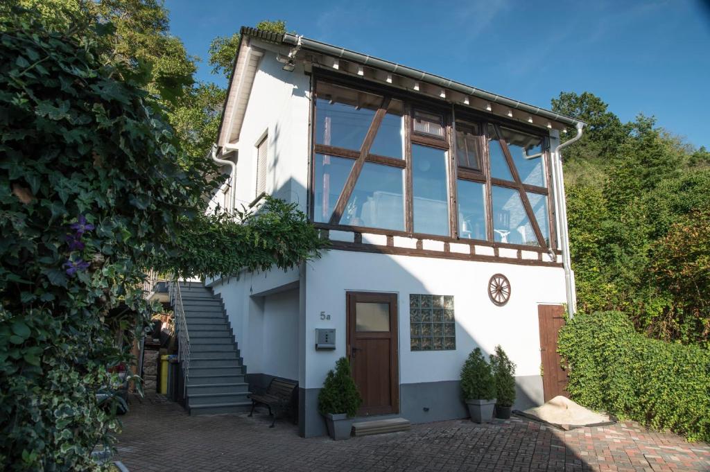 une maison avec une grande fenêtre et des escaliers dans l'établissement 4 Sterne Ferienwohnung Rabenlay, à Oberneisen