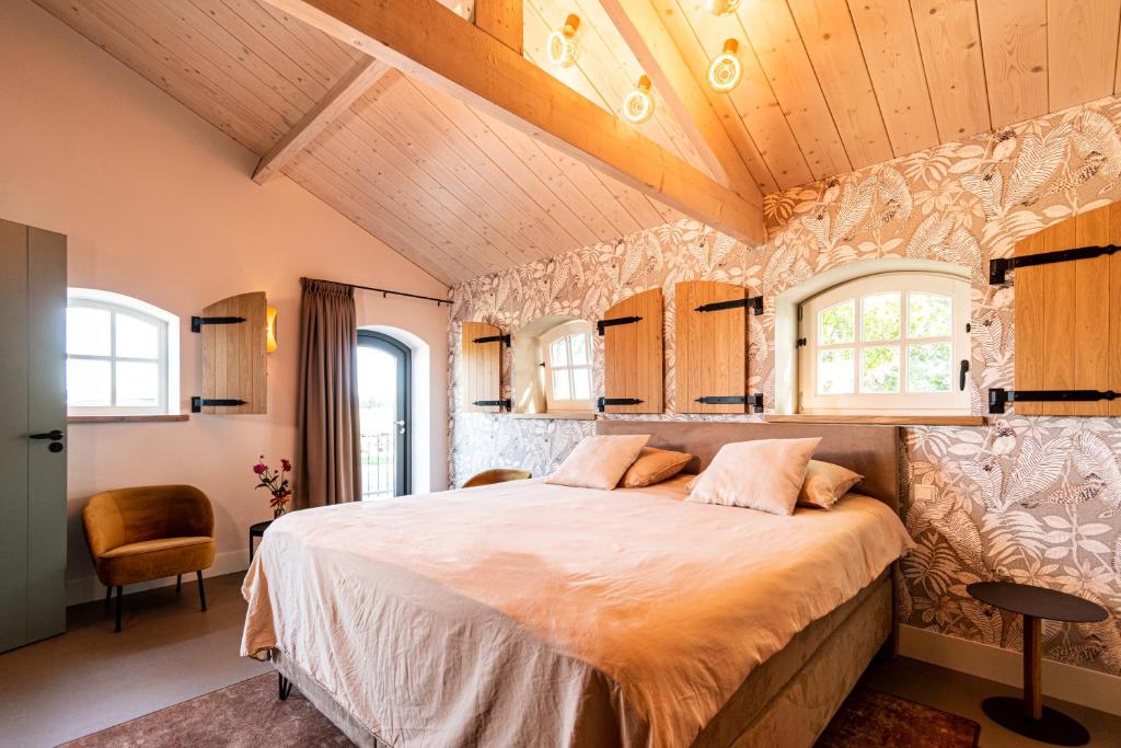 Melderslo的住宿－B&B De NieuwenHof 'De Voorkamer'，一间带一张大床的卧室,位于一个拥有木制天花板的房间