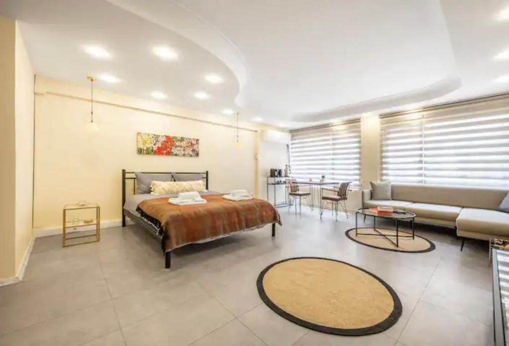 ein Schlafzimmer mit einem Bett, einem Sofa und einem Tisch in der Unterkunft Osmanbey’de geniş stüdyo daire in Istanbul