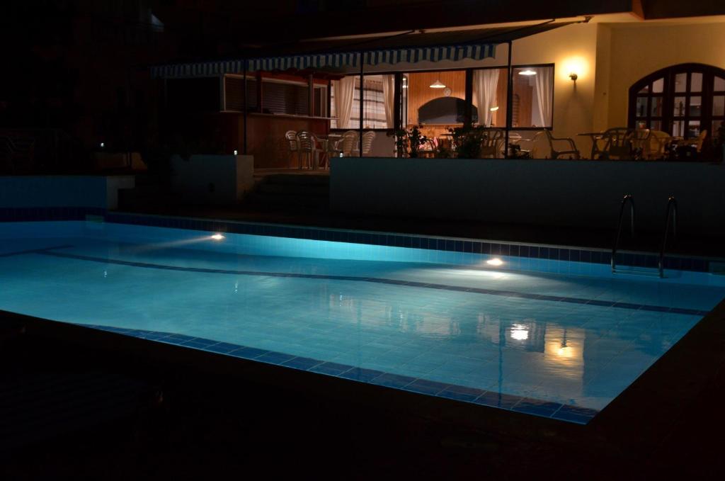 a swimming pool lit up at night at Hotel Thisvi in Stalís