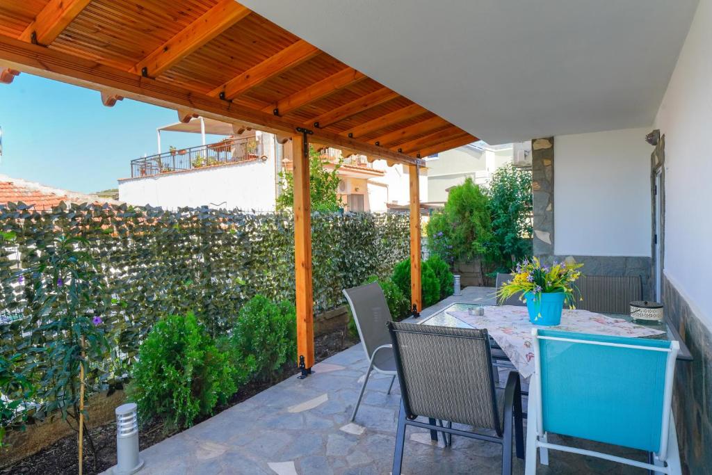 a patio with a table and chairs under a pergola at Thomas Apartments in Skala Marion