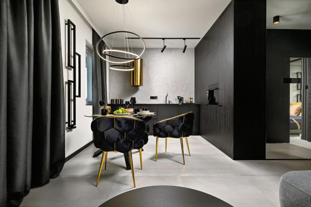 ein Esszimmer mit schwarzen Wänden sowie einem Tisch und Stühlen in der Unterkunft Black&Gold Apartament in Płock