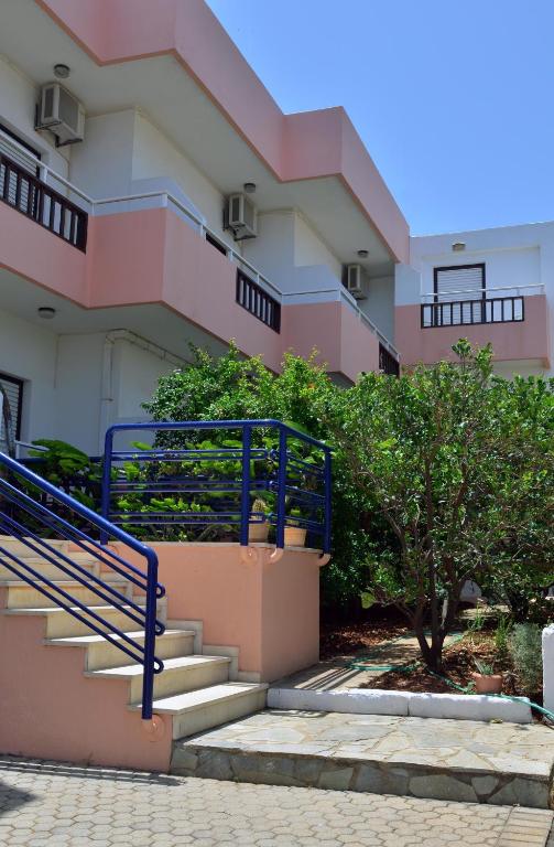 a building with stairs and a blue railing at Hotel Thisvi in Stalís
