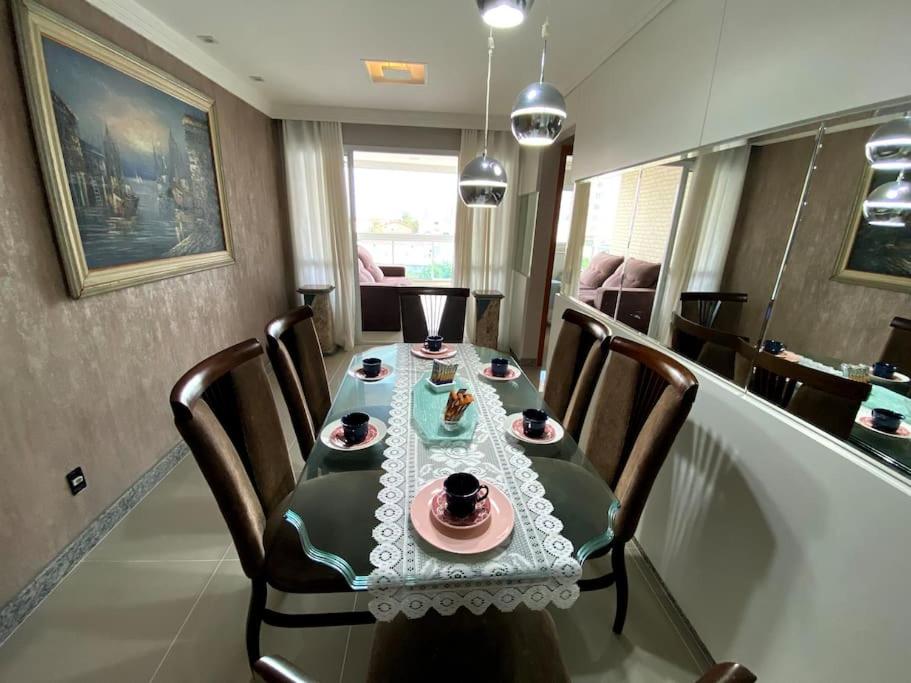 a dining room with a table and chairs with plates and drinks at 3 Quartos vila velha Praia de Itaparica in Vila Velha