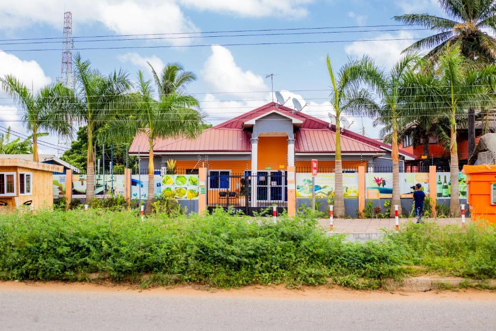 una casa colorida con una valla delante en Sweet Home Guest House, en Sogakofe