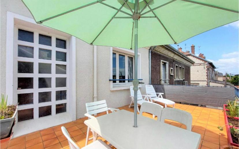 a table with a green umbrella on a patio at appartement t3 terrasse in Troyes