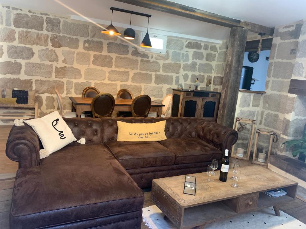 a living room with a brown couch and a table at appartement de charme centre historique de Brive in Brive-la-Gaillarde