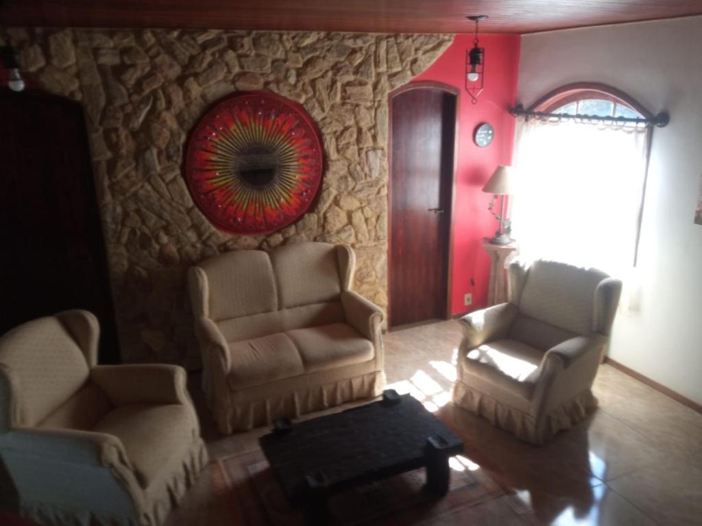 uma sala de estar com duas cadeiras e um espelho em Amaencanto em Paty do Alferes