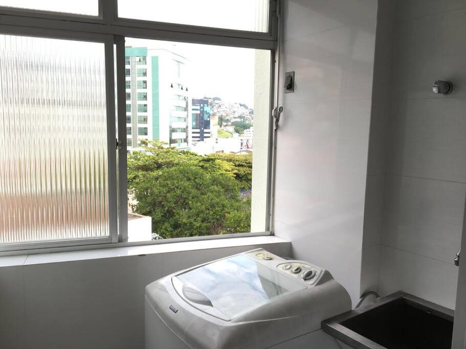 a bathroom with a window and a washing machine at Não é studio, apto espaçoso 70m, 2 quartos, sacada fechada, garagem e bem no centro in Florianópolis