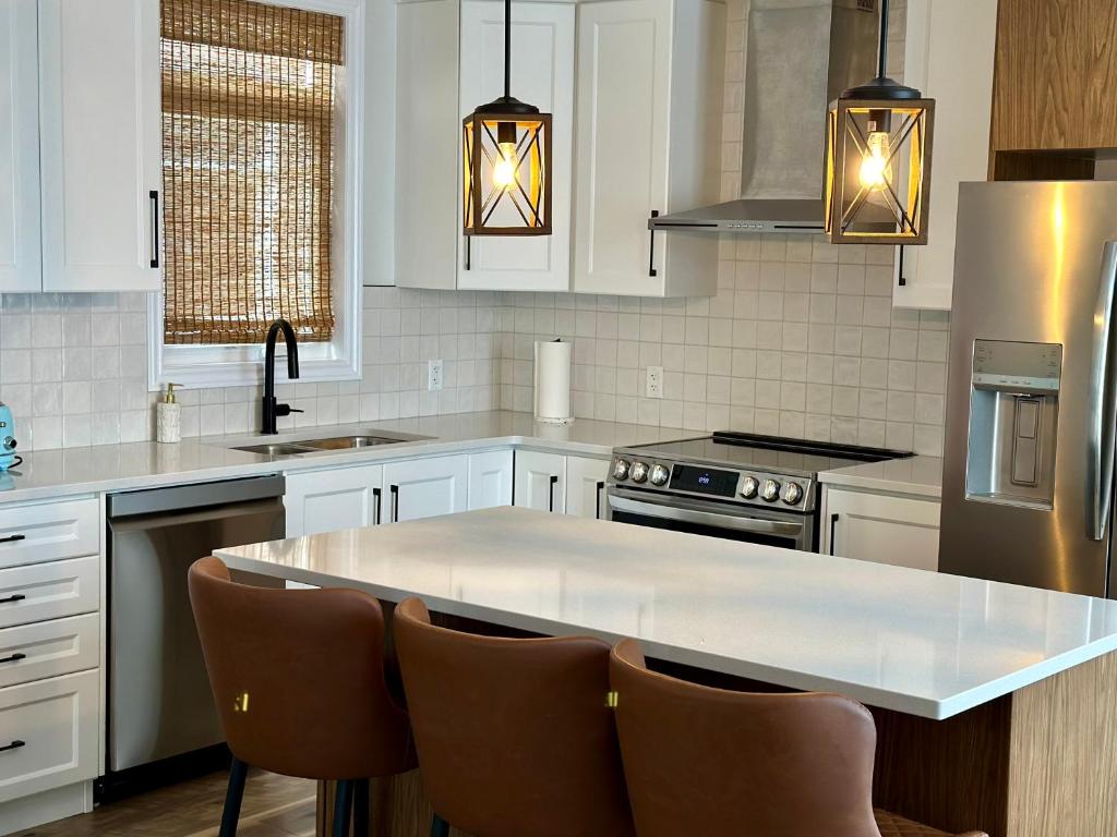 uma cozinha com armários brancos e um balcão branco em Luxury Detached House Kingston em Kingston