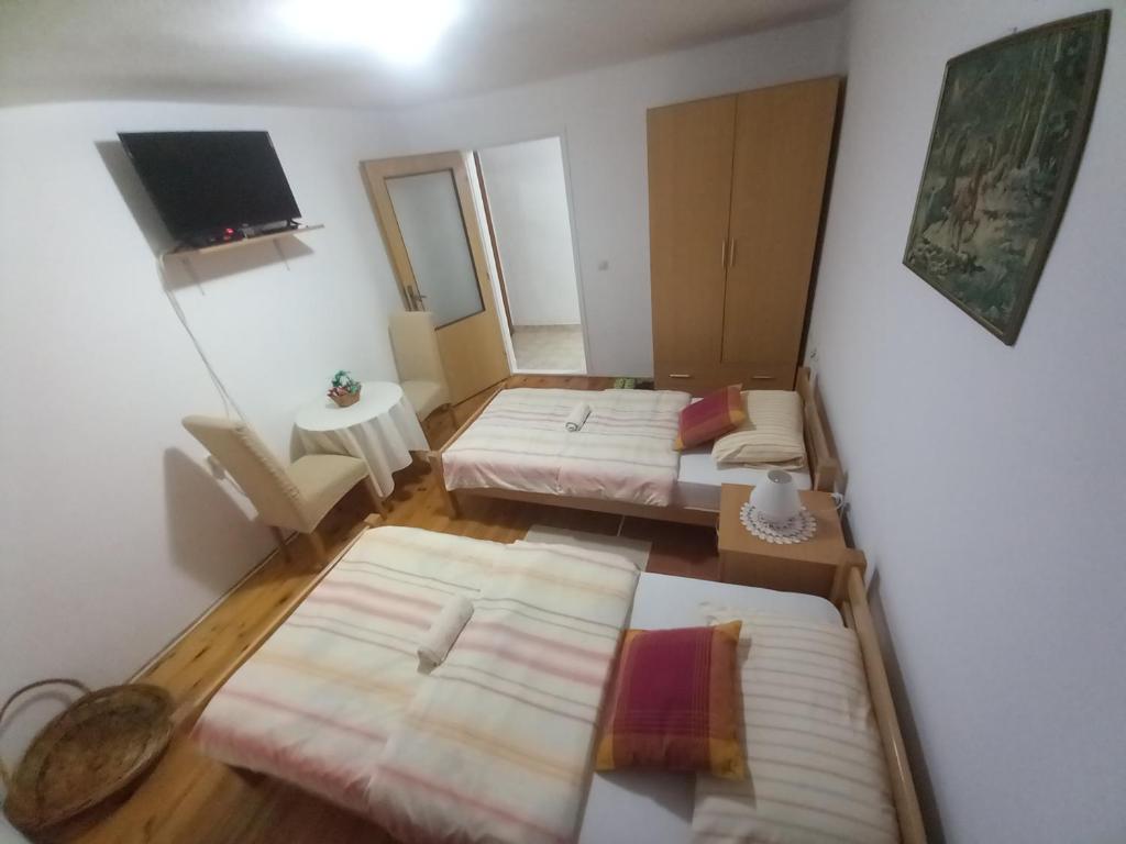 um quarto com três camas e uma tv nele em Sobe Dujakovic 