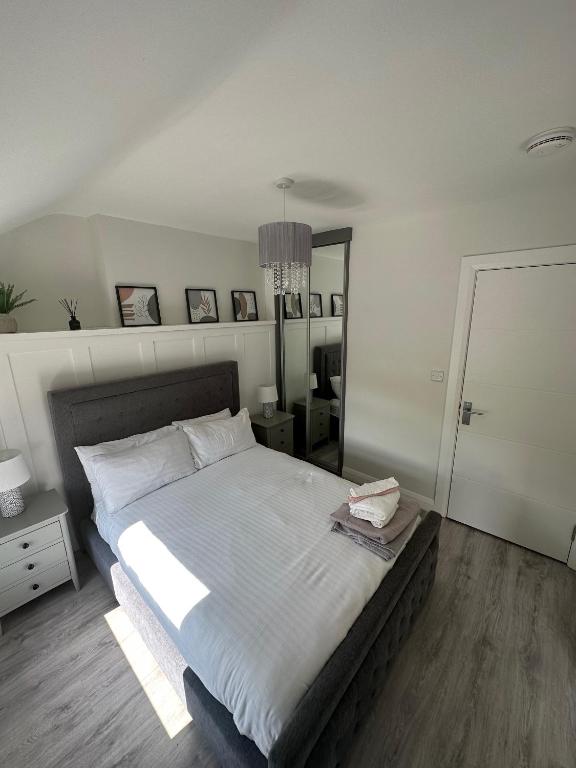 1 dormitorio con 1 cama grande y espejo grande en Westland Suites - Stylish, Modern, Elegant, Central Apartments A en Derry