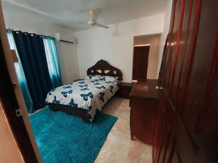 ein Schlafzimmer mit einem Bett und einem blauen Teppich in der Unterkunft Apartamento Amueblado in Neiba