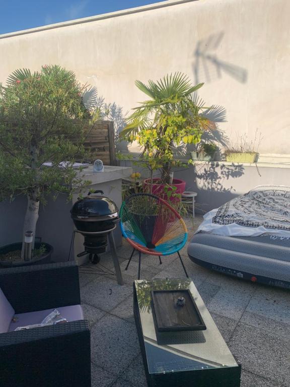 a room with potted trees and a bed and a table at Penthouse avec jacuzzi in Asnières-sur-Seine