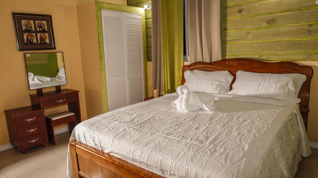 a bedroom with a large bed with a wooden headboard at Incognito Culture Rooms in Kingston