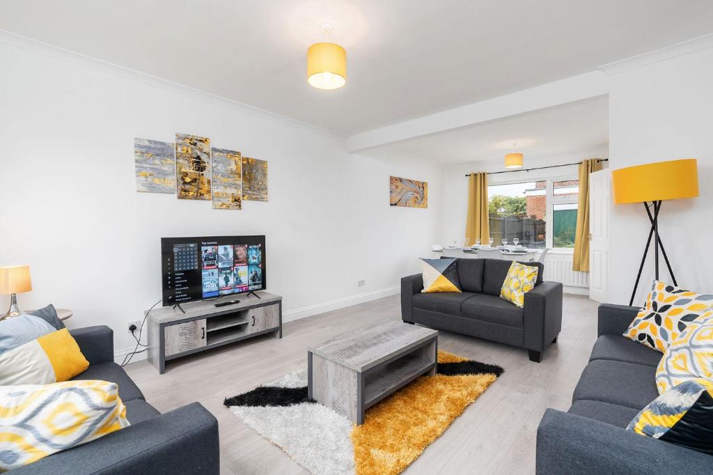 a living room with two couches and a tv at Spacious Modern Home in Sheffield in Todwick