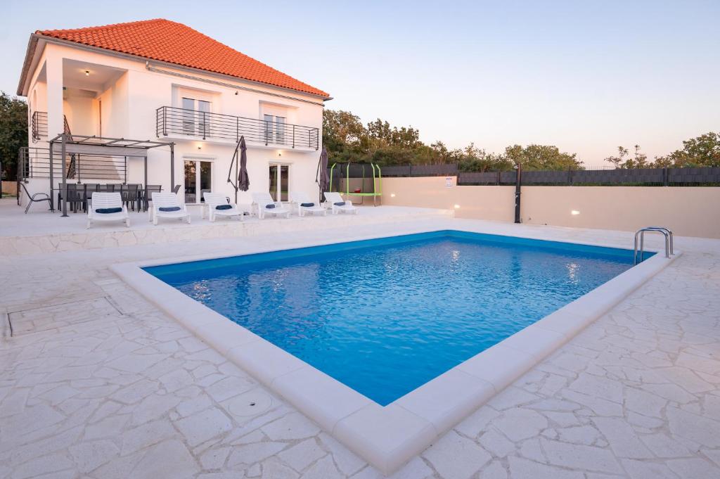 a swimming pool in front of a house at Kuća za odmor Kamenjani-Škabrnja in Škabrnje