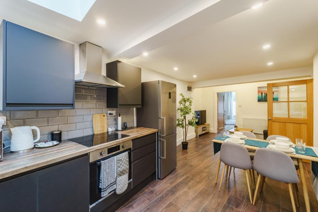 een keuken met een tafel en stoelen in een kamer bij Augusta lodge Moseley in Birmingham