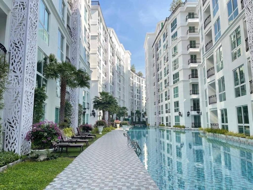 un complesso di appartamenti con piscina tra due edifici di Olympus City Garden By Saowanee a Pattaya Sud