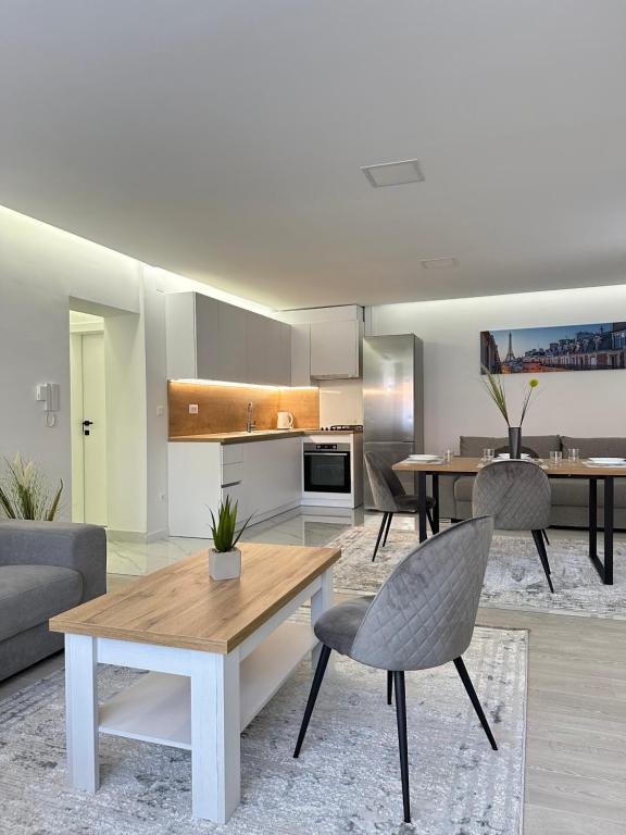 Una sala de estar con una mesa y una cocina. en Rozi apartments, en Zagreb